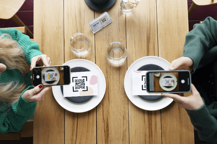 Clientes escaneando código QR de menú en restaurante