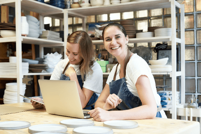 Autónomas gestionando tienda de cerámica desde ordenador portátil