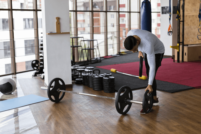 Hombre preparándose para levantar pesas en gimnasio