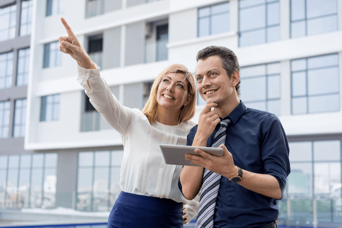 Pareja feliz explorando opciones de compra de un apartamento con tablet