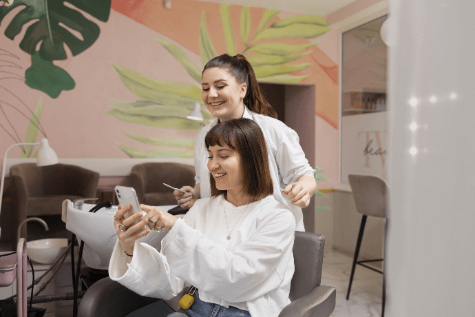 Estilista y cliente disfrutando de sesión de peluquería en salón moderno