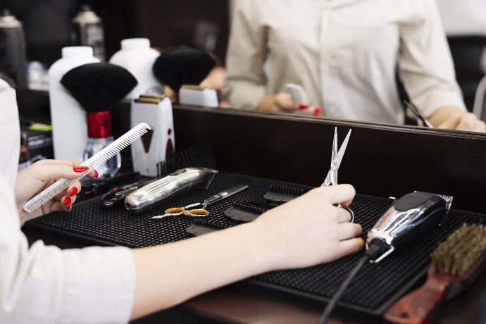 Estilista preparando herramientas de peluquería en salón de belleza