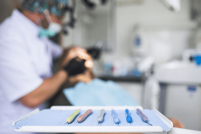 Dentista trabajando con instrumentos dentales en clínica