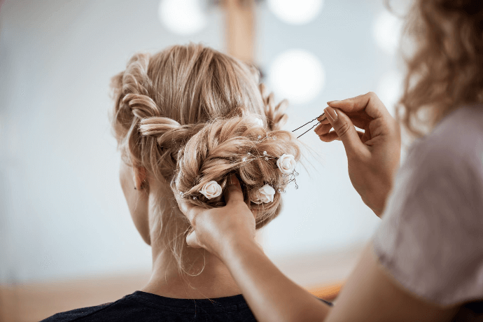 Estilista creando peinado elegante en salón de belleza